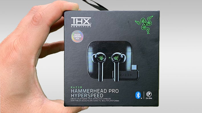 Holding a Razer Hammerhead Pro Hyperspeed earbuds retail package in front of a gray gradient background.
