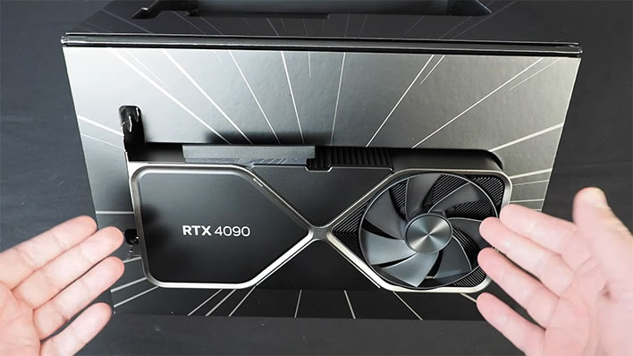 Hands pointing to a GeForce RTX 4090 in its retail box.