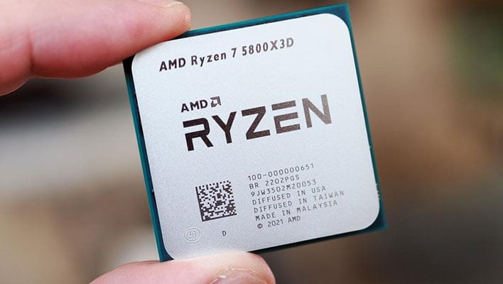 Two fingers holding an AMD Ryzen 7 5800X3D processor.