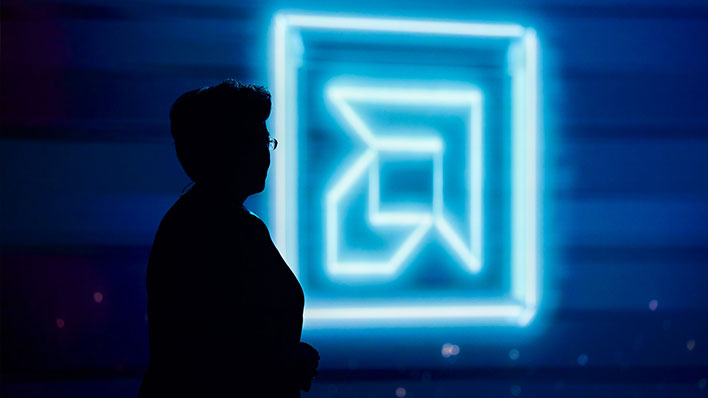 Silhouette of AMD CEO Dr. Lisa Su in front of an AMD logo.