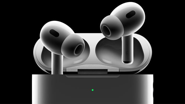 Apple AirPods Pro (2nd Gen) earbuds protroding from their charging case on a black background.