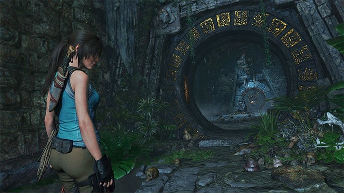 Shadow of the Tomb Raider screenshot showing Lara Croft outside a rocky entranceway.