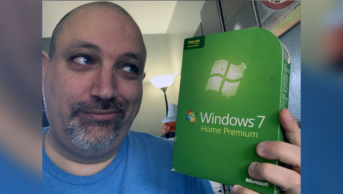 Holding a Windows 7 retail box.
