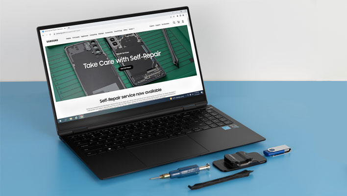 Samsung Galaxy Book with a 'Self Repair' promo page on the screen and iFixIt tools on the table.