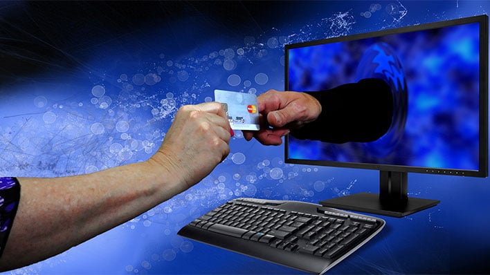 Hand reaching out of a monitor and grabbing a credit card from another person's hand.