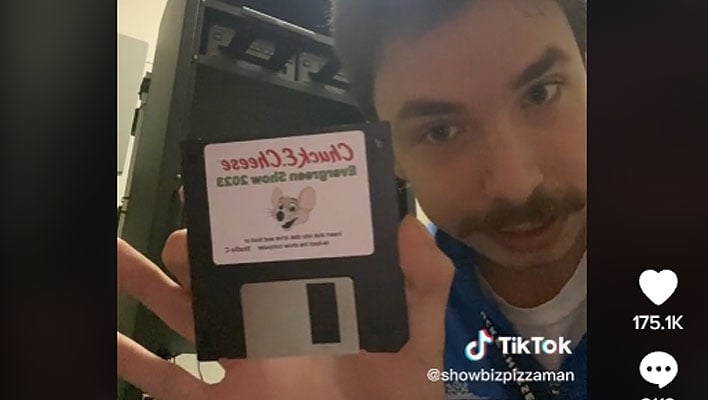 Chuck E. Cheese employee holding a floppy disk that's used to update the store's shows.