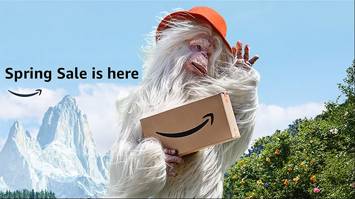 Amazon banner for its Spring Sale. Shows an abominable snowman holding an Amazon package with snowy mountains and a blue sky in the background.