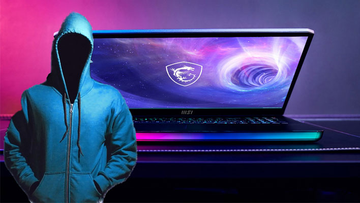 Hacker in a hoodie in front of an MSI laptop.