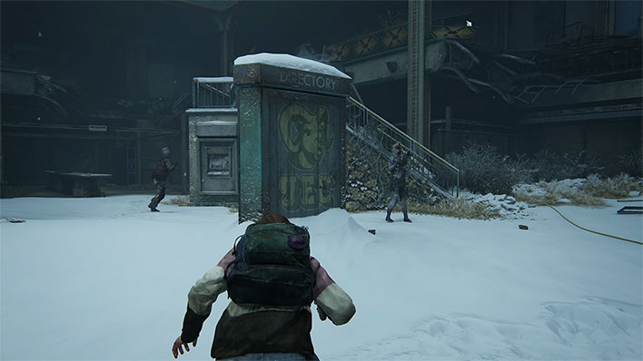 Character sneaking in the snow in The Last of Us Part I.