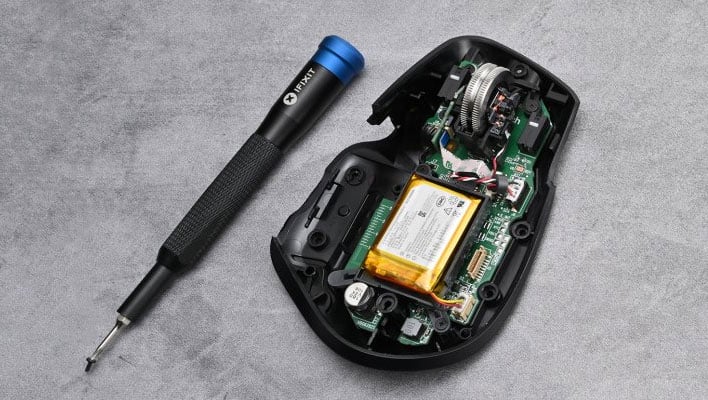 An iFixIt screwdriver next to a Logitech mouse that's been opened to expose its internal hardware.