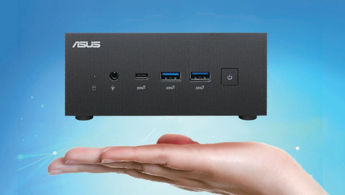 ASUS mini PC hovering above the palm of a hand in front of a blue background.