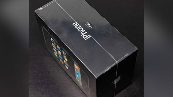 Sealed first-gen iPhone on a black background.