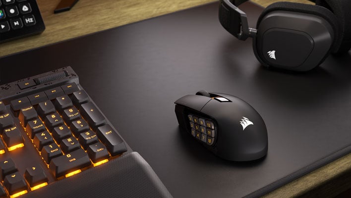 Corsair Scimitar Elite Wireless gaming mouse on a desk next to a keyboard and headset.