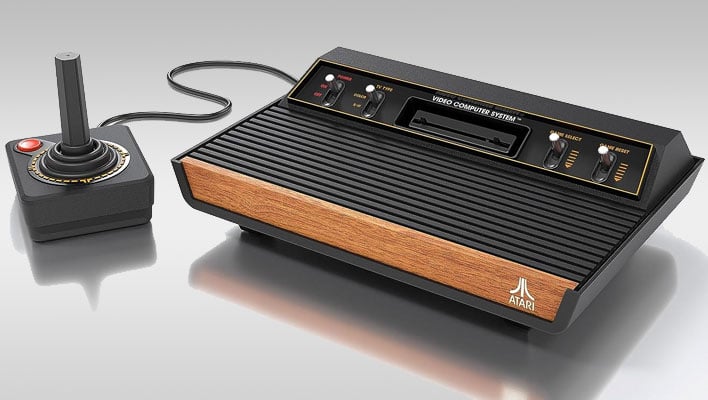 Atari 2600+ console with a joystick on a gray gradient background.