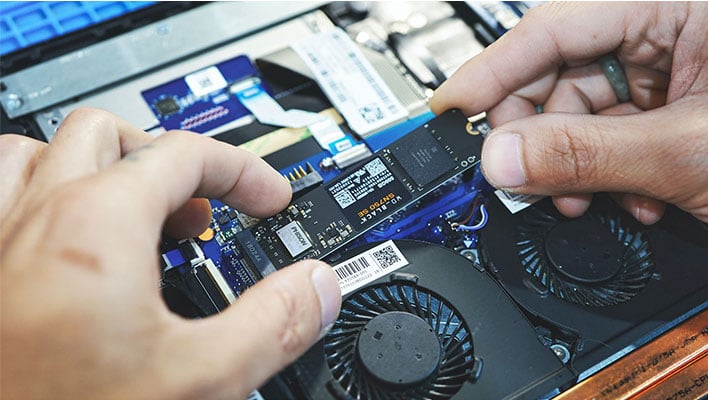 An SSD being installed in a laptop.