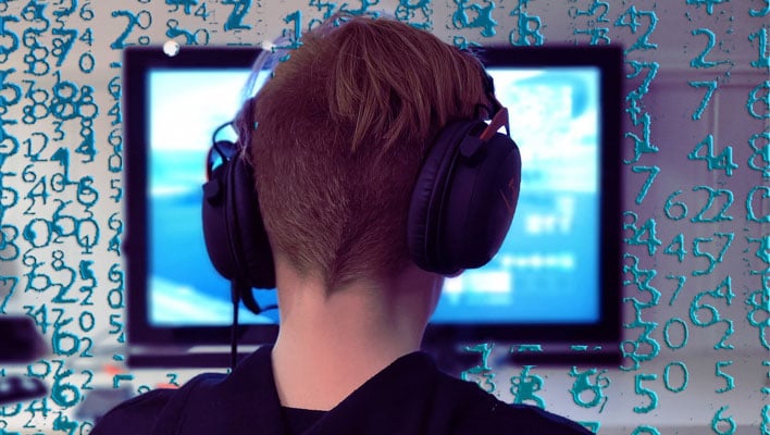 Back of a gamer's head wearing headphones, in front of a display.