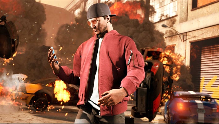 Grand Theft Auto character holding a smartphone while cars explode in the background.