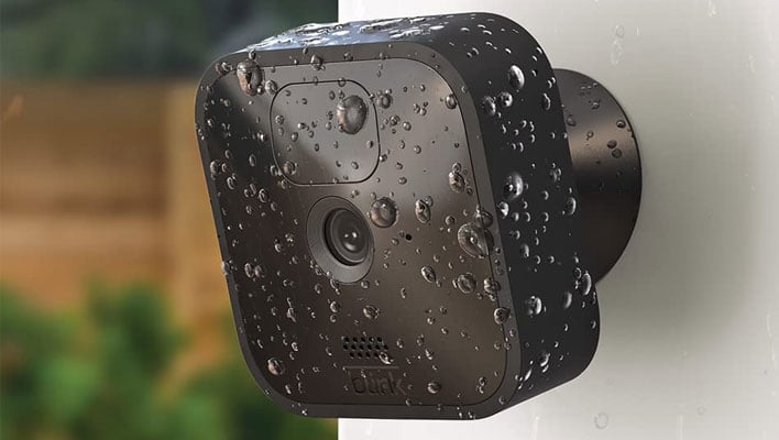 Blink Outdoor security camera mounted to a home and drenched in raindrops.