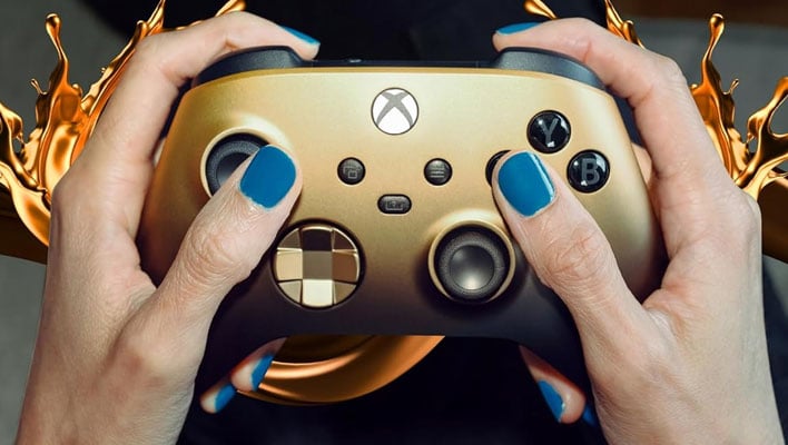 Person with blue fingernails holding a Microsoft Xbox Wireless Controller - Gold Shadow Special Edition with liquid gold splashing in the background.  