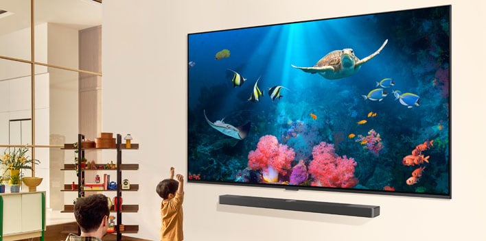 LG's 98-inch mini LED QNED TV on a wall in a living room.