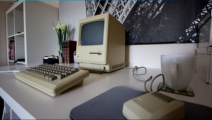 Original Apple Macintosh on a desk.