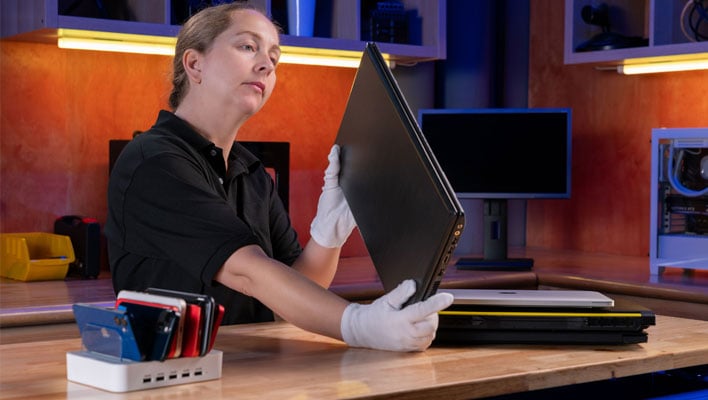 A woman inspecting a laptop.