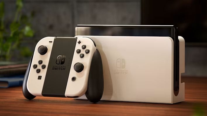 NIntendo Switch OLED inside a dock and next to the Joy-Cons on a table.