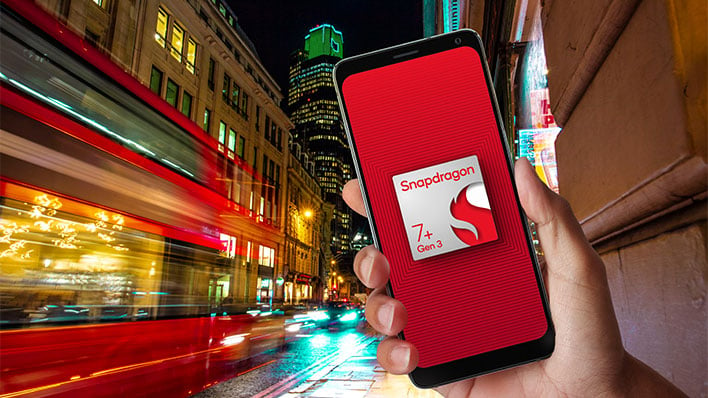 Hand holding a smartphone with a render of Qualcomm's Snapdragon 7+ Gen 3 on the display, in front of a city-themed background.