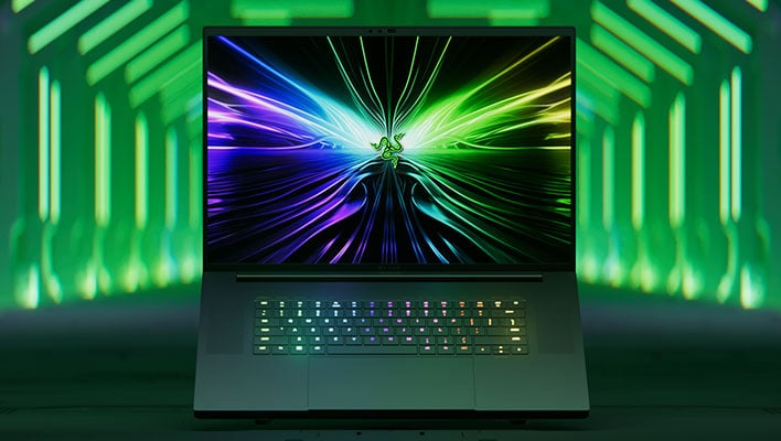 Razer Blade 18 open in front of a background with lines of green lights.