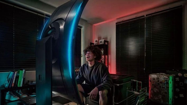 A gamer looking up at a Samsung Odyssey Ark 2nd Gen monitor in portrait mode.