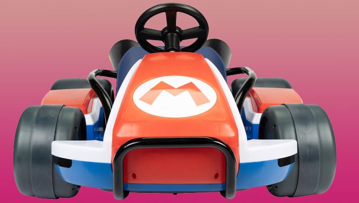 JAKKS Pacific Mario Kart 24V Ride-On Racer on a red and pink gradient background.
