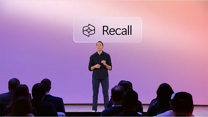 Yusef Mehdi on stage in front of a Recall image.