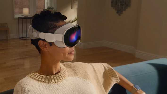 Femme assise sur un canapé portant un casque Apple Vision Pro.