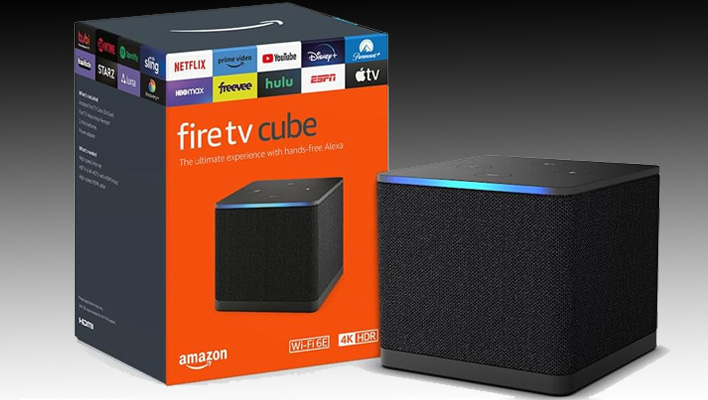 Amazon Fire TV Cube with retail packaging on a black and gray gradient background.