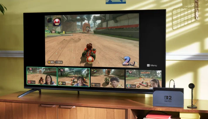 Nintendo Switch 2 console in a dock next to a TV and microphone.