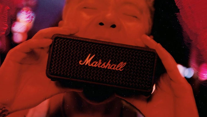 Marshall Emberton III Bluetooth speaker in front of a person's mouth.