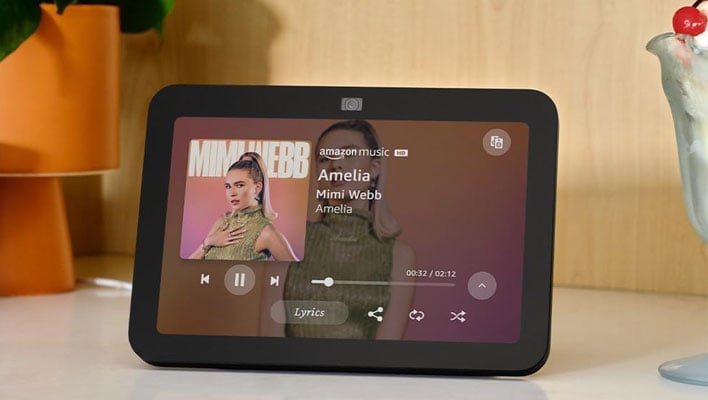 Amazon Echo Show 8 on a counter next to a glass of ice cream with a cherry on top.