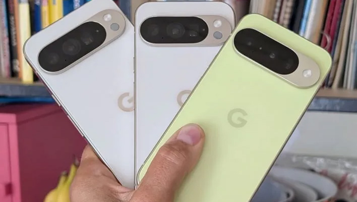 Hand holding three Pixel 10 handsets (Pixel 10, Pixel 10 Pro, and Pixel 10 Pro XL).