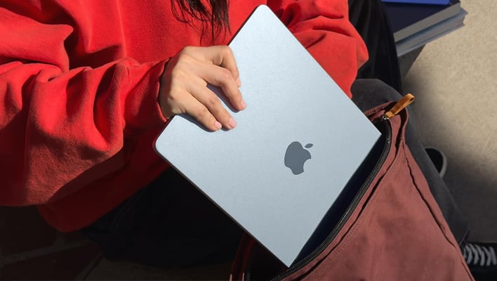 Apple MacBook Air being shoved into a bag.