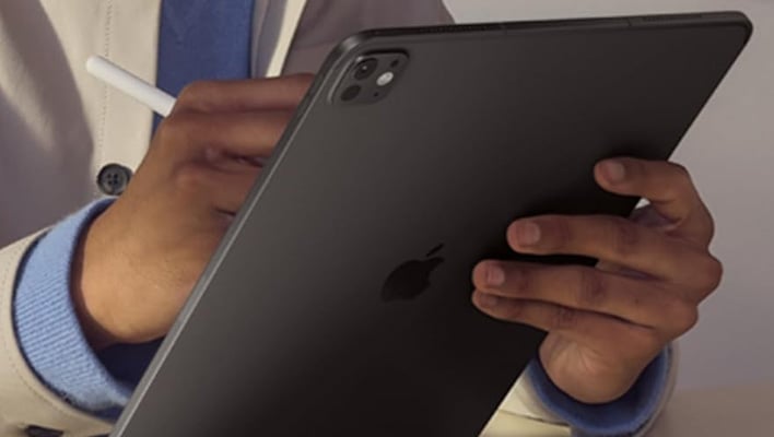 Rear shot of an 11-inch iPad Pro being held by a man.
