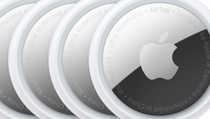Closeup render of four Apple AirTag (1st gen) trackers.