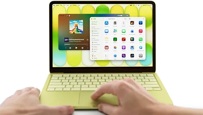 Hands on an open, yellow MacBook Neo.