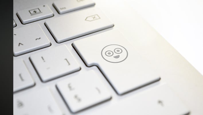 Laptop keyboard with a smiling face on the return key.
