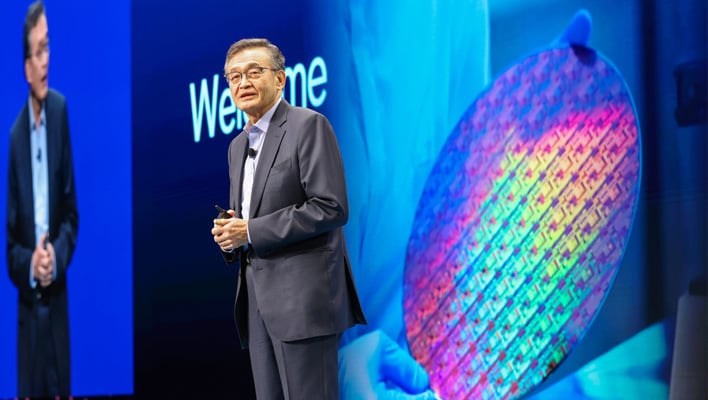 Intel CEO Lip-Bu Tan on stage in front of an image of a wafer.