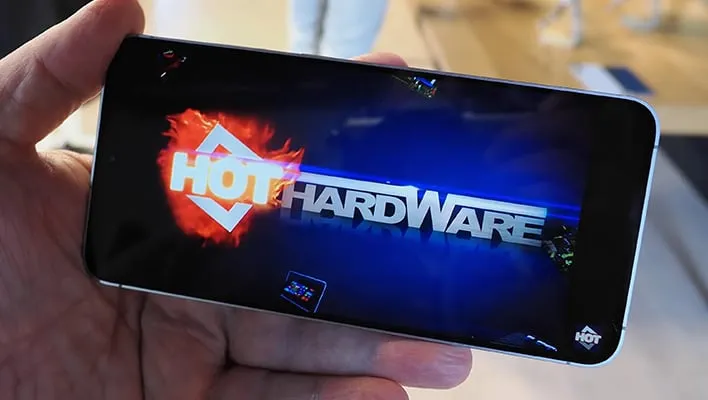 Holding a Samsung Galaxy S25 FE with "HotHardware" on the display.
