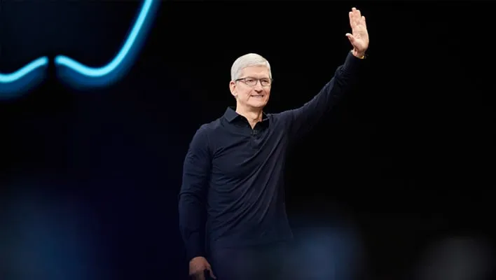 Apple CEO Tim Cook waving on stage.