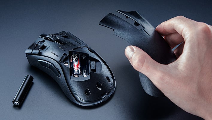 Hand removing the cover from Razer's DeathAdder V2 X HyperSpeed gaming mouse.